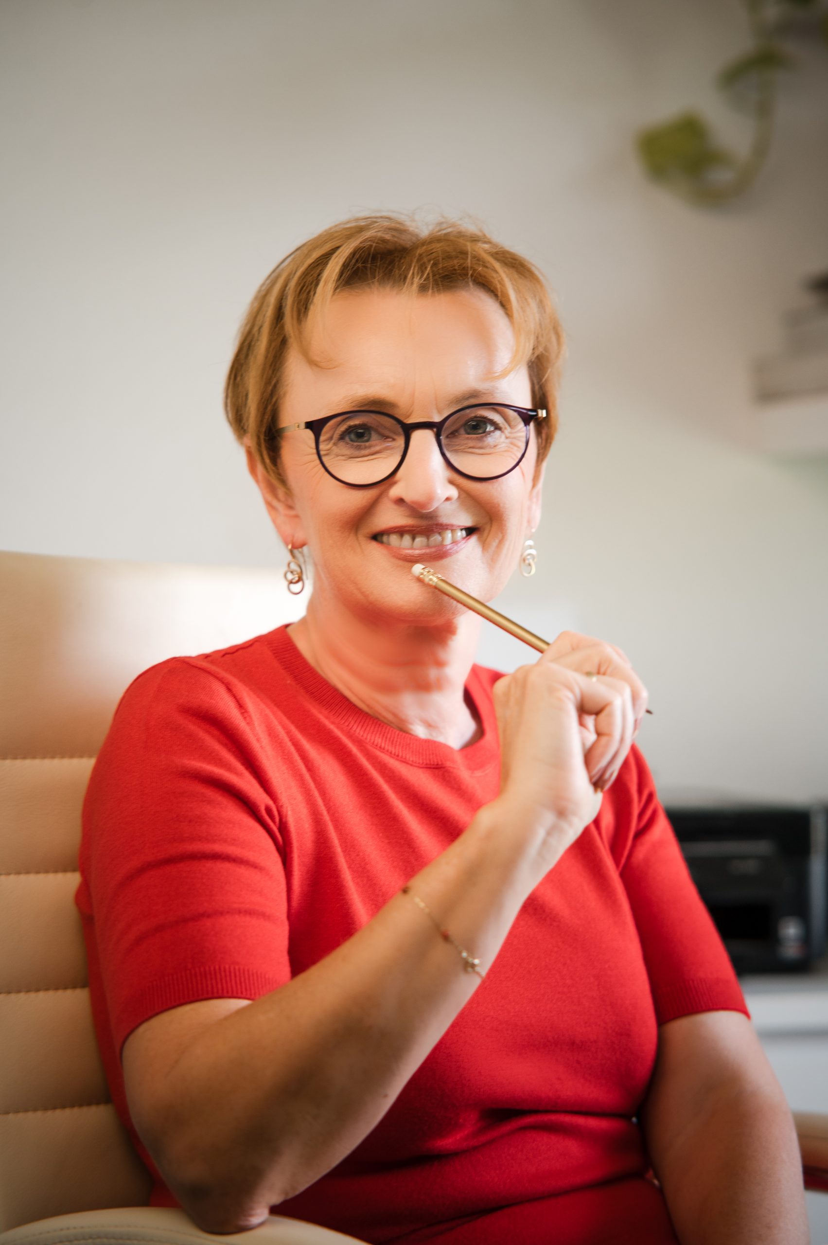 Monika Lackner, Portrait mit Stift, nachdenklich lächelnd
