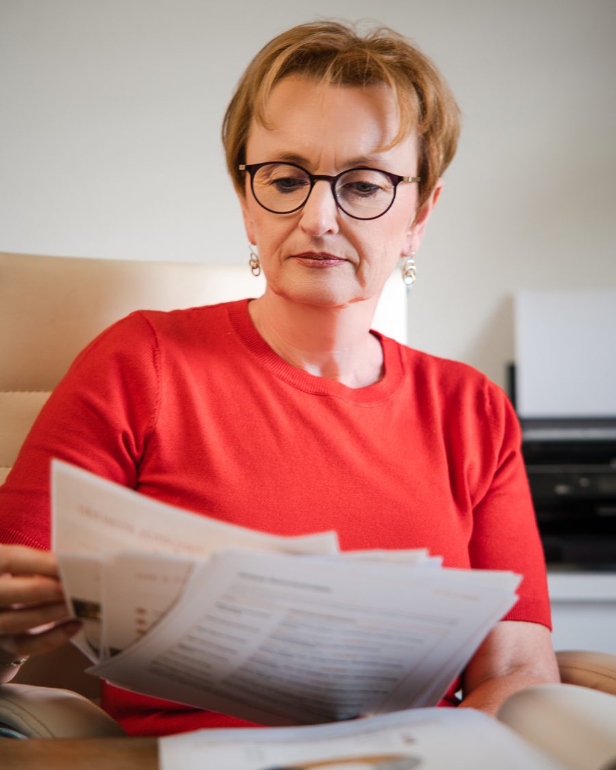 Monika Lackner prüft Unterlagen an ihrem Schreibtisch